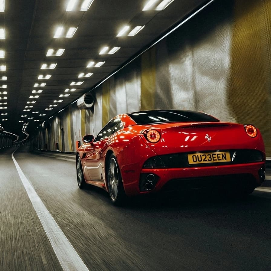 Photo of a Rosso Corsa Ferrari California T showing the private number plate OU23 EEN, which reads as Queen and is currently available for sale for £13,250.